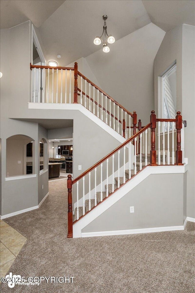 stairway with high vaulted ceiling and carpet