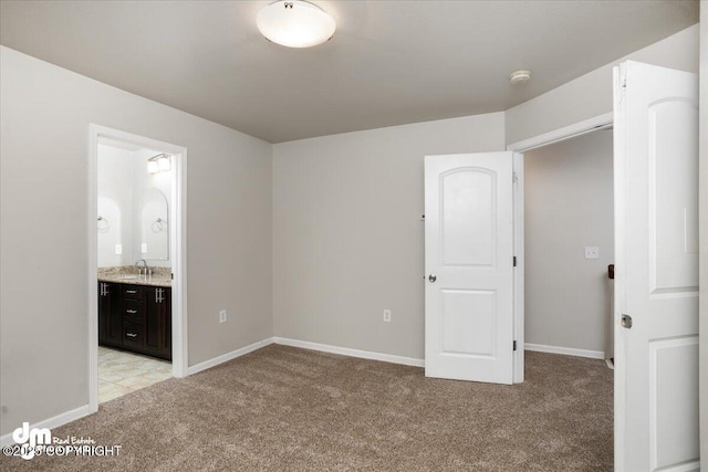 unfurnished bedroom with light colored carpet, sink, and ensuite bath