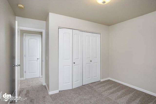 unfurnished bedroom with a closet and light carpet