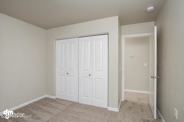 unfurnished bedroom featuring a closet and light carpet