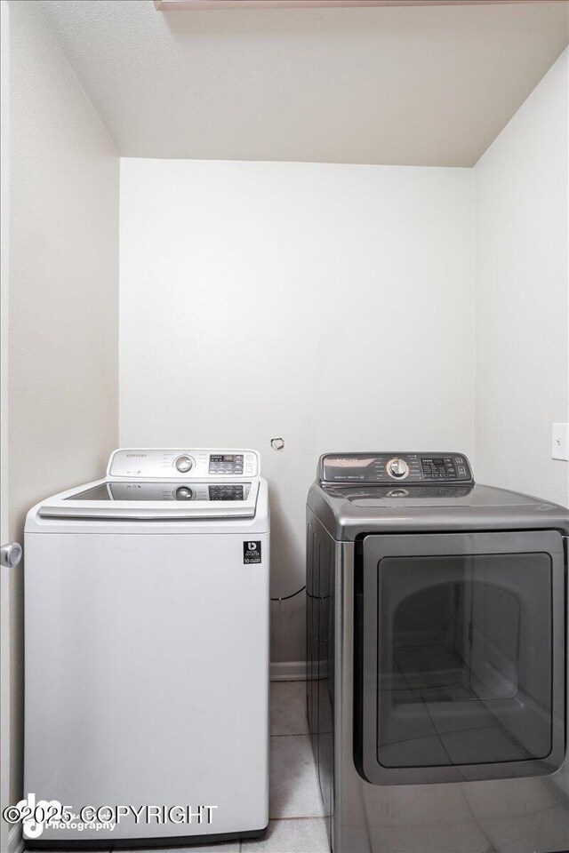 laundry room featuring washer and dryer and light tile patterned floors