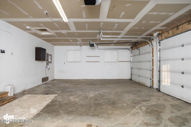 garage with a garage door opener and electric panel