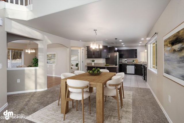 dining room featuring light carpet and an inviting chandelier