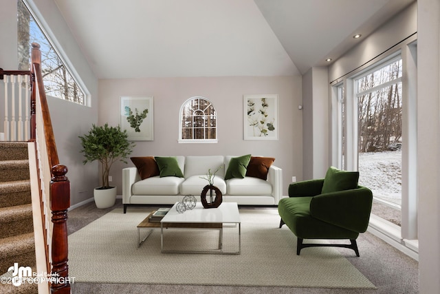 living room featuring vaulted ceiling, carpet, and plenty of natural light