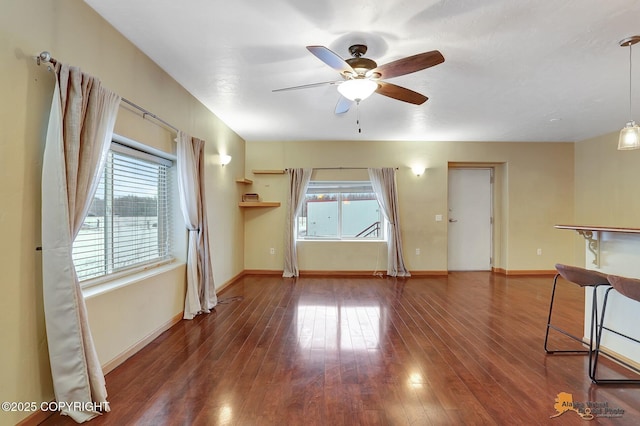 unfurnished living room featuring dark hardwood / wood-style floors and ceiling fan