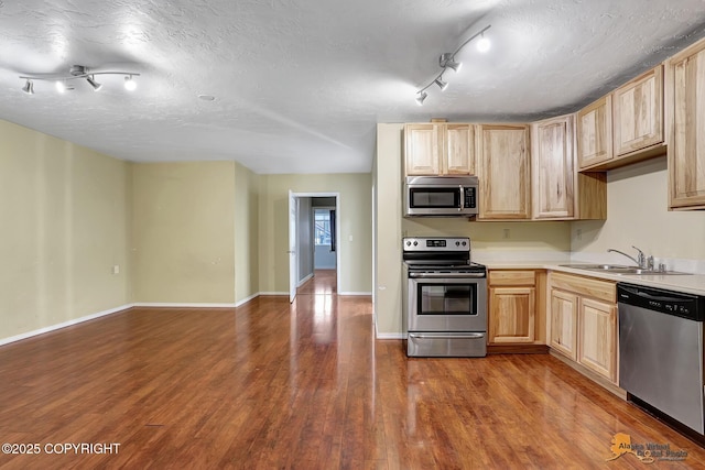 kitchen featuring stainless steel appliances, sink, a textured ceiling, and light brown cabinetry