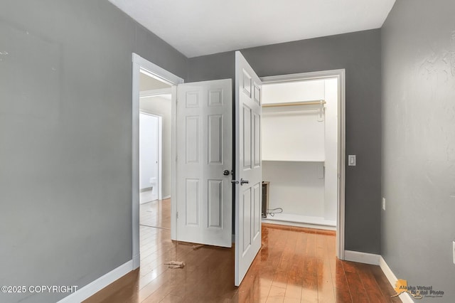 corridor with hardwood / wood-style flooring