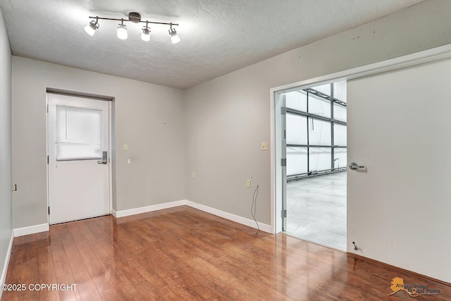 unfurnished room featuring hardwood / wood-style floors and a textured ceiling