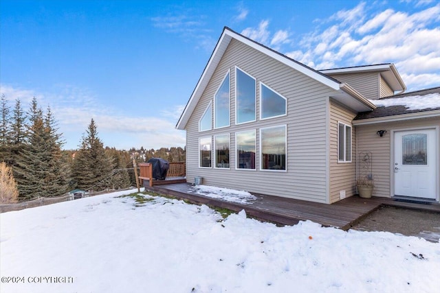 view of snow covered exterior with a wooden deck