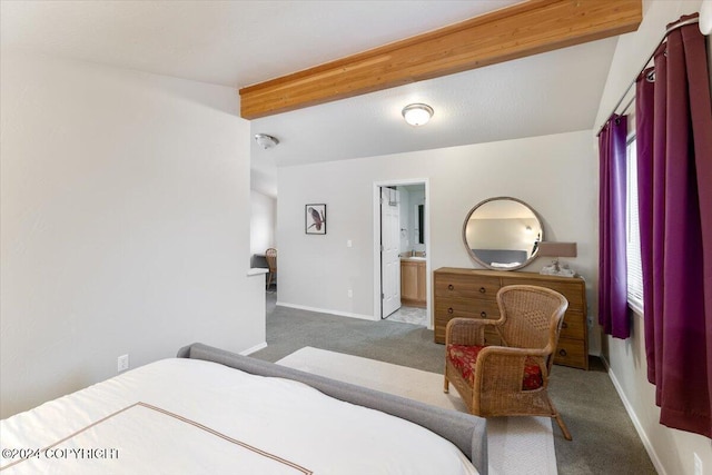 bedroom with beam ceiling, ensuite bath, and carpet