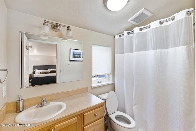 bathroom with a shower with curtain, vanity, a textured ceiling, and toilet