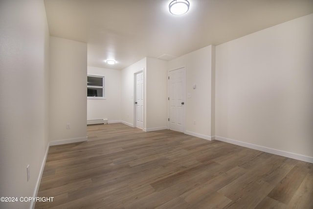 spare room featuring hardwood / wood-style flooring and baseboard heating