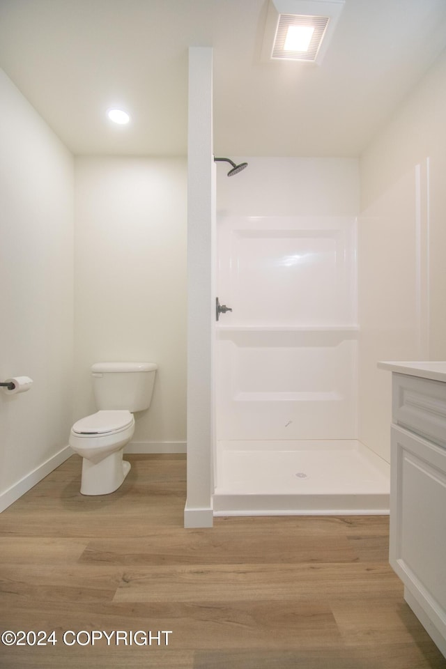 bathroom with walk in shower, toilet, vanity, and hardwood / wood-style flooring