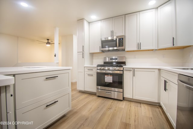 kitchen with ceiling fan, white cabinets, light wood-type flooring, and appliances with stainless steel finishes