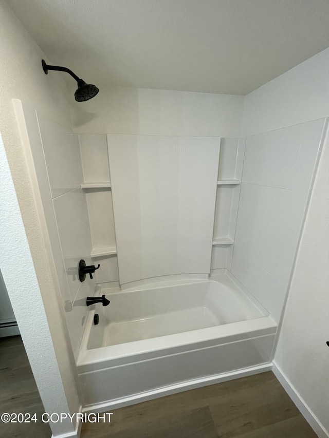 bathroom featuring shower / bath combination, hardwood / wood-style flooring, and a baseboard heating unit