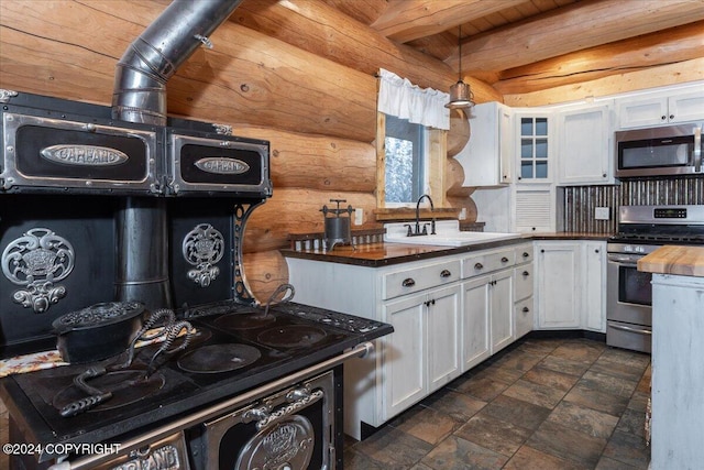 TL-215 Old Valdez Trl, Salcha, AK 99714 - kitchen with appliances with stainless steel finishes, wooden counters, white cabinetry, pendant lighting, and glass insert cabinets