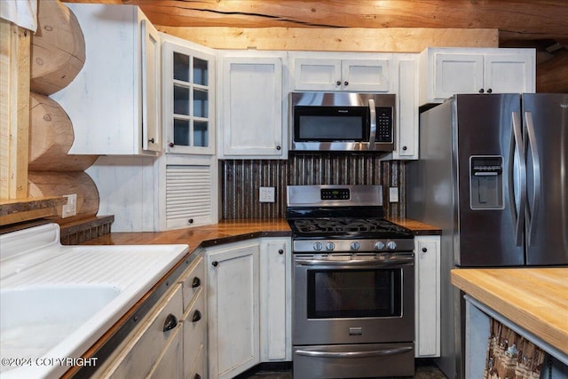 TL-215 Old Valdez Trl, Salcha, AK 99714 - kitchen featuring appliances with stainless steel finishes, white cabinetry, butcher block counters, and glass insert cabinets