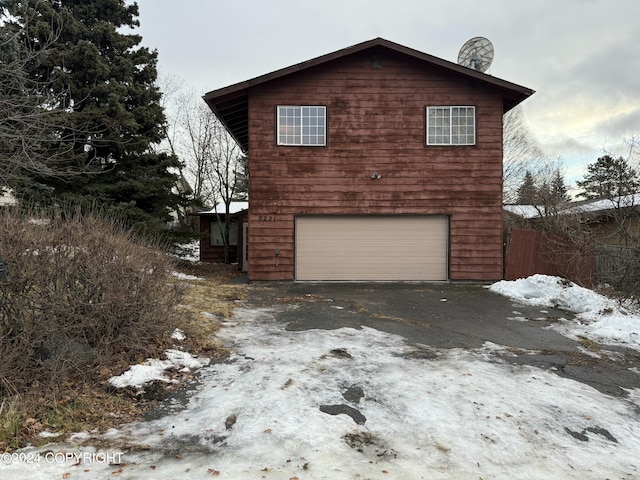 view of snowy exterior featuring a garage