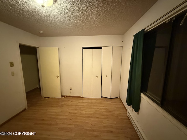 9231 Campbell Ter, Anchorage, AK 99515 - unfurnished bedroom with light wood-style floors, a closet, and a textured ceiling