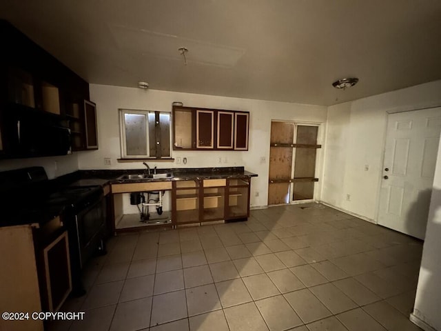 kitchen featuring light tile patterned floors, sink, and black appliances