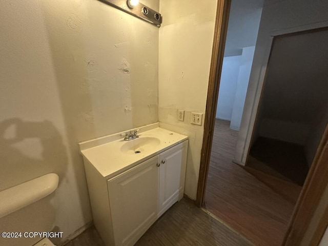 bathroom with hardwood / wood-style floors, vanity, and toilet