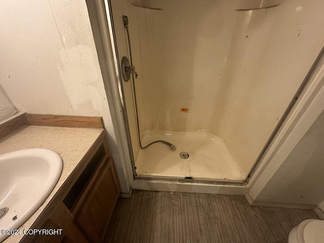 bathroom with walk in shower, toilet, vanity, and hardwood / wood-style flooring