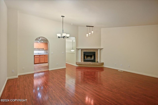 unfurnished living room featuring a chandelier, hardwood / wood-style floors, and high vaulted ceiling