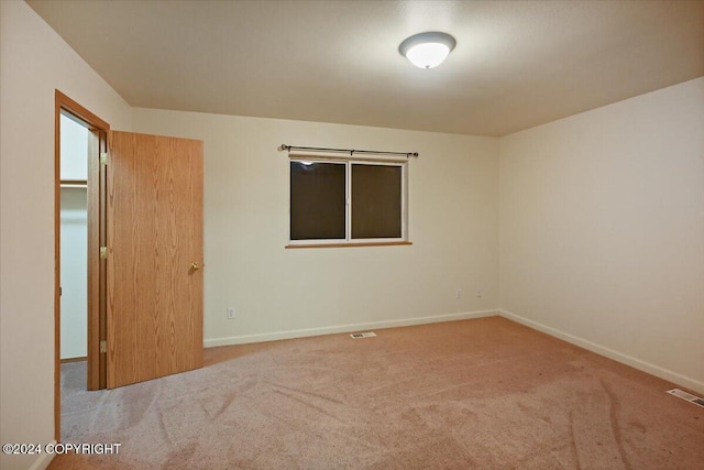 unfurnished room featuring light carpet