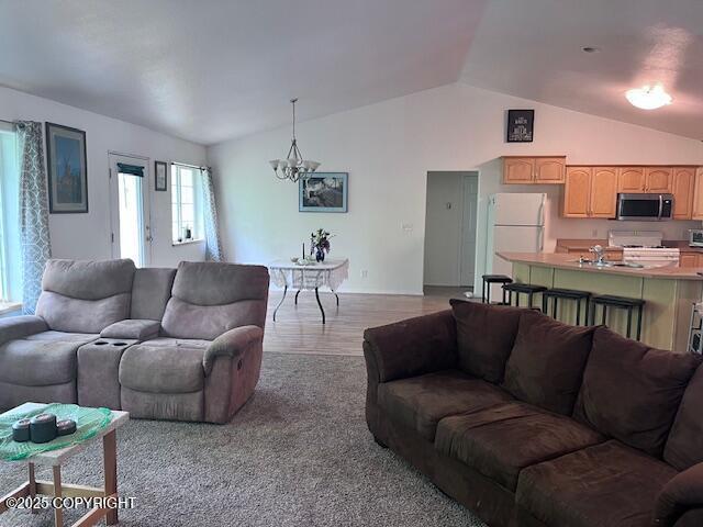 4570 S Navigators Cir, Wasilla, AK 99623 - living area featuring lofted ceiling, a chandelier, and light wood finished floors