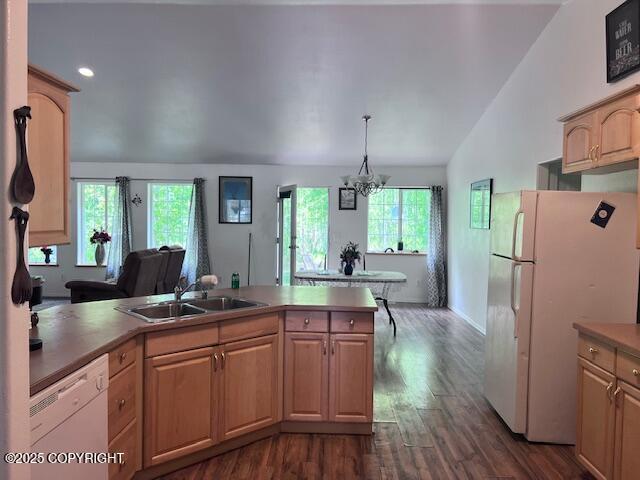 4570 S Navigators Cir, Wasilla, AK 99623 - kitchen with white appliances, a sink, lofted ceiling, dark wood-type flooring, and a peninsula