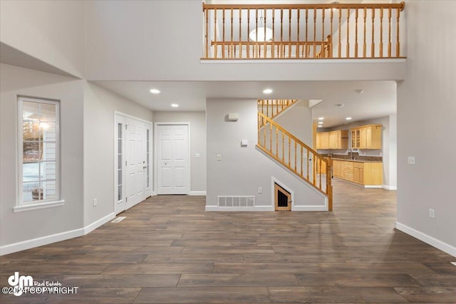 foyer featuring sink, dark wood-type flooring, and a high ceiling