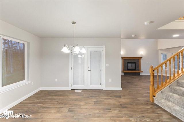 unfurnished dining area featuring dark hardwood / wood-style floors and a chandelier