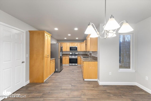 kitchen featuring sink, decorative light fixtures, dark hardwood / wood-style floors, a notable chandelier, and stainless steel appliances