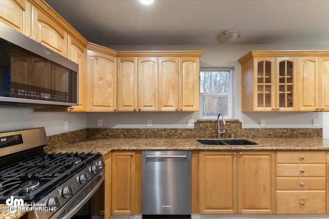 kitchen featuring light brown cabinetry, sink, stainless steel appliances, and stone countertops