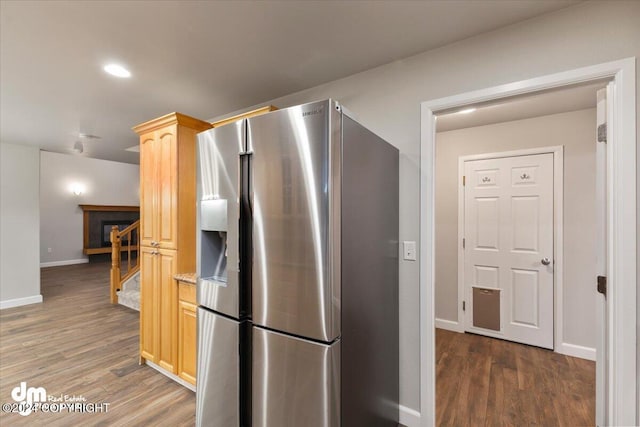 kitchen featuring dark hardwood / wood-style flooring, stainless steel fridge, and light brown cabinetry