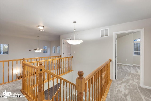 hallway featuring light colored carpet