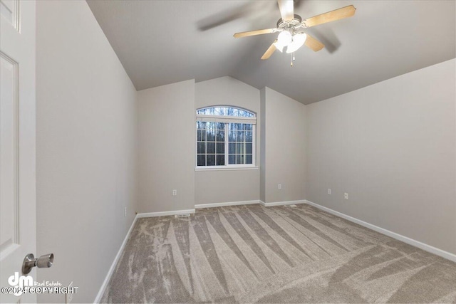 carpeted spare room featuring lofted ceiling and ceiling fan