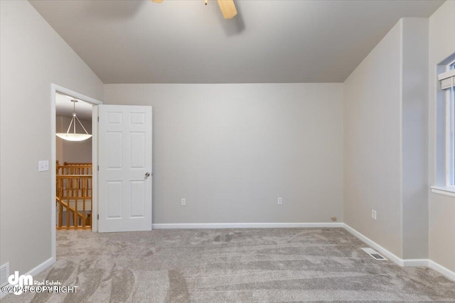 carpeted spare room with ceiling fan