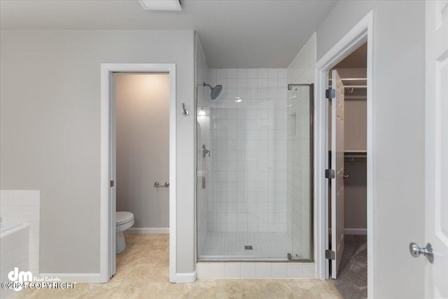 bathroom with tile patterned floors, toilet, and a shower with door