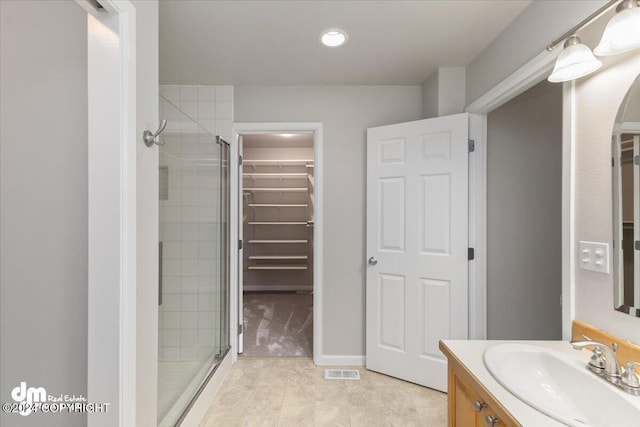 bathroom featuring tile patterned floors, vanity, and a shower with door