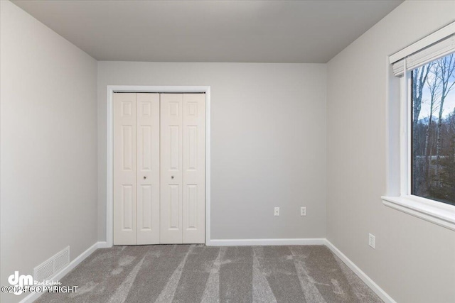 unfurnished bedroom featuring carpet floors and a closet