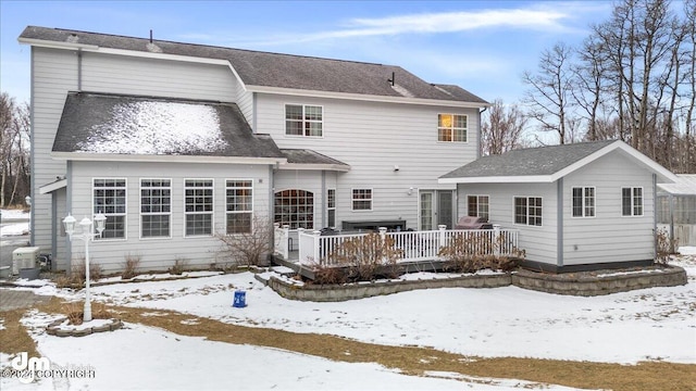 snow covered property with a deck