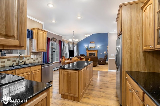 kitchen with a kitchen island, sink, decorative backsplash, ornamental molding, and stainless steel appliances