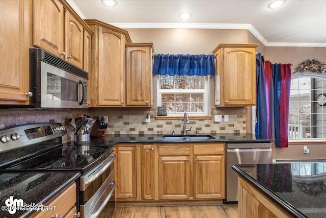 kitchen with sink, crown molding, appliances with stainless steel finishes, decorative backsplash, and dark stone counters