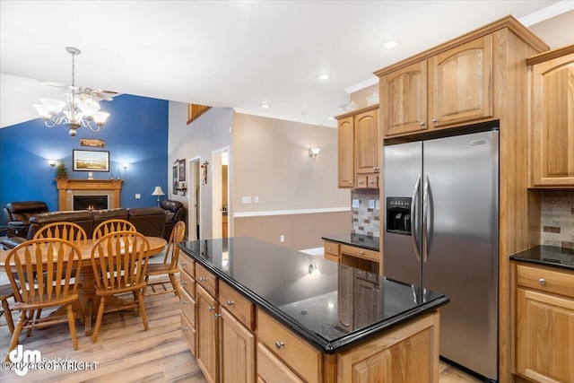 kitchen with stainless steel fridge, a center island, tasteful backsplash, light hardwood / wood-style floors, and dark stone counters