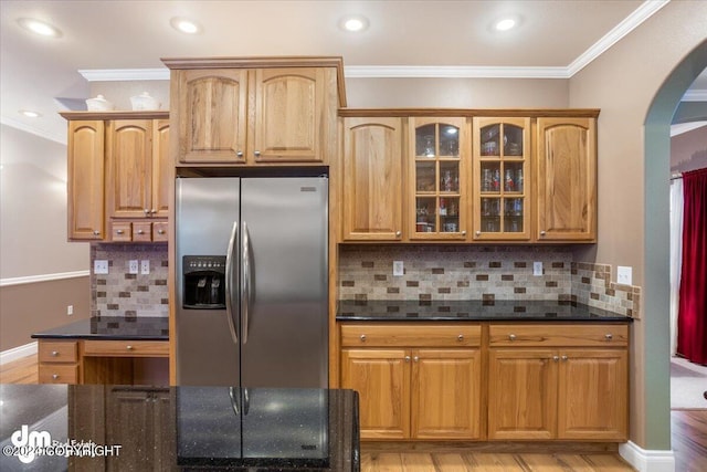 kitchen with decorative backsplash, light wood-type flooring, ornamental molding, and stainless steel refrigerator with ice dispenser