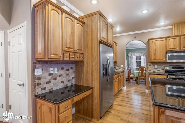 kitchen featuring dark stone countertops, backsplash, light hardwood / wood-style flooring, and appliances with stainless steel finishes