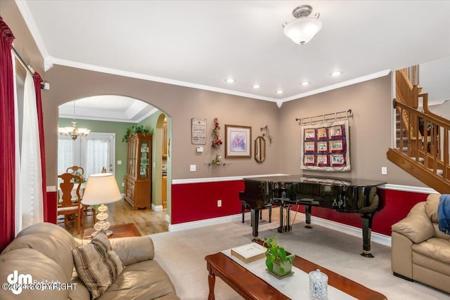 carpeted living room with ornamental molding and a chandelier