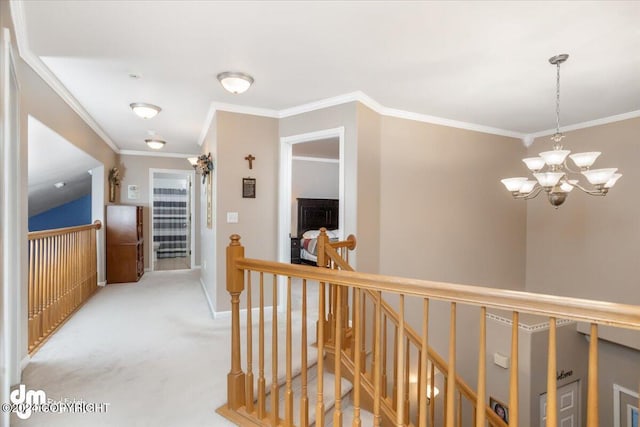 hallway with a notable chandelier, crown molding, and carpet