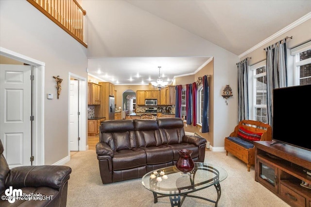 carpeted living room featuring crown molding, a chandelier, and high vaulted ceiling